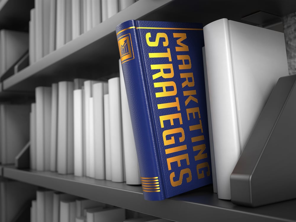 Marketing Strategies - Blue Book on the Black Bookshelf between white ones.